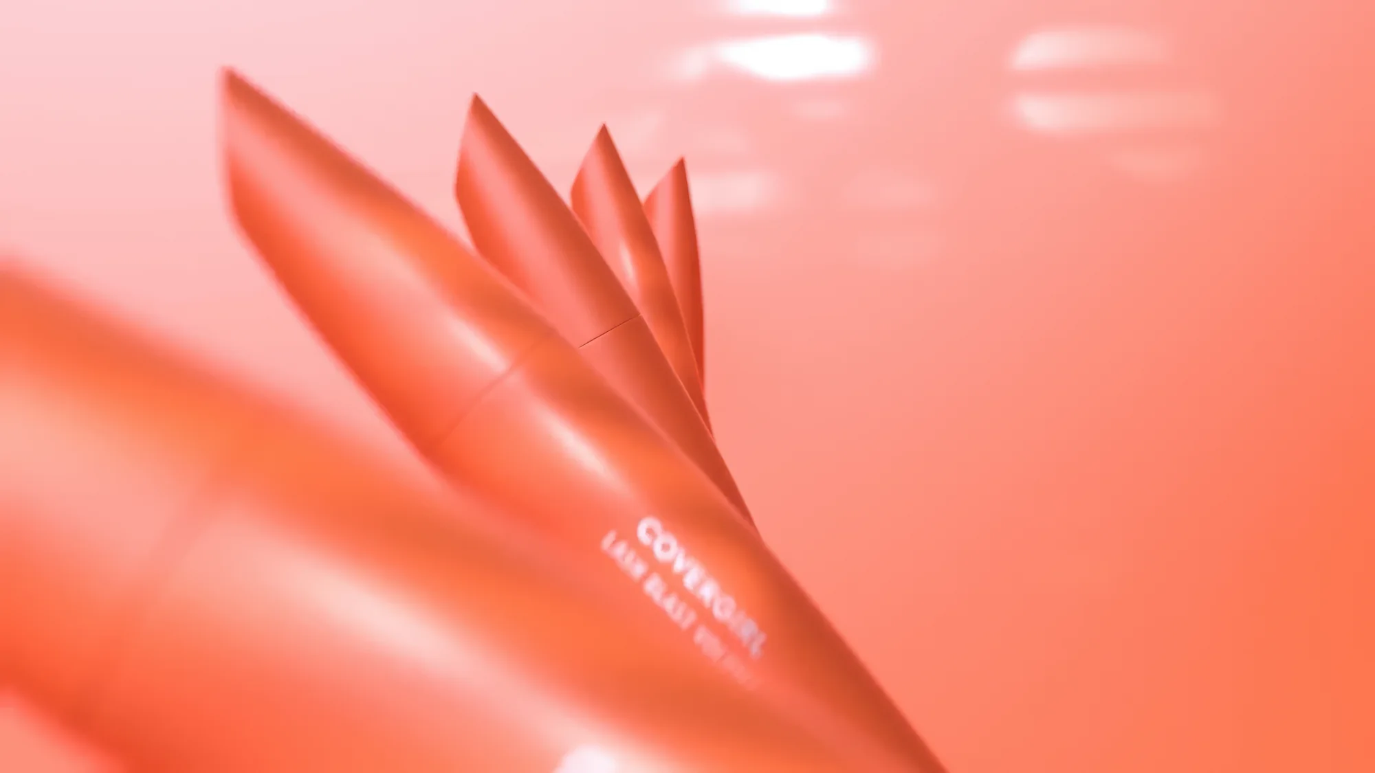 Cosmetics art direction: coral packshot in a monochrome palette